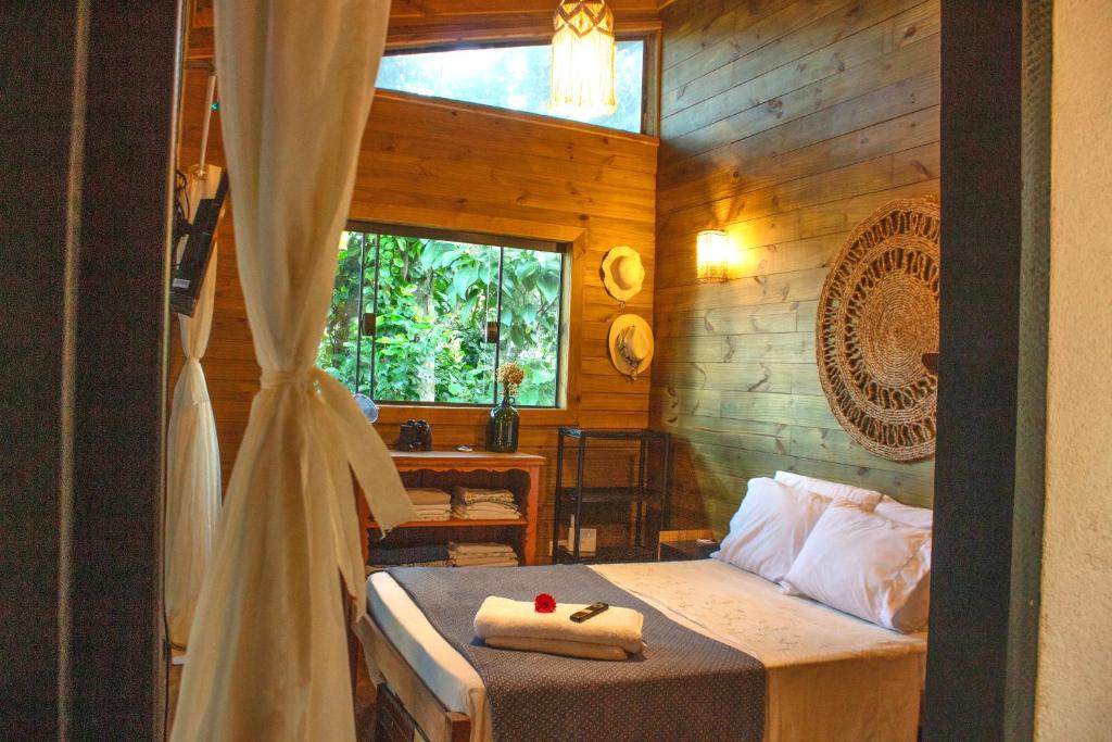 una camera da letto con un letto con asciugamani sopra di Eco Cabana a 150 metros da praia e centrinho a Parati