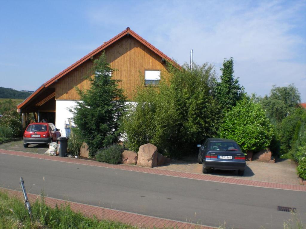 a house with two cars parked in front of it at Ferienwohnung Weilerbach in Weilerbach