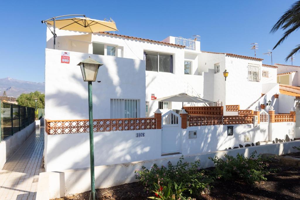 un edificio blanco con una luz de la calle delante de él en Soul House Tenerife, en Costa del Silencio