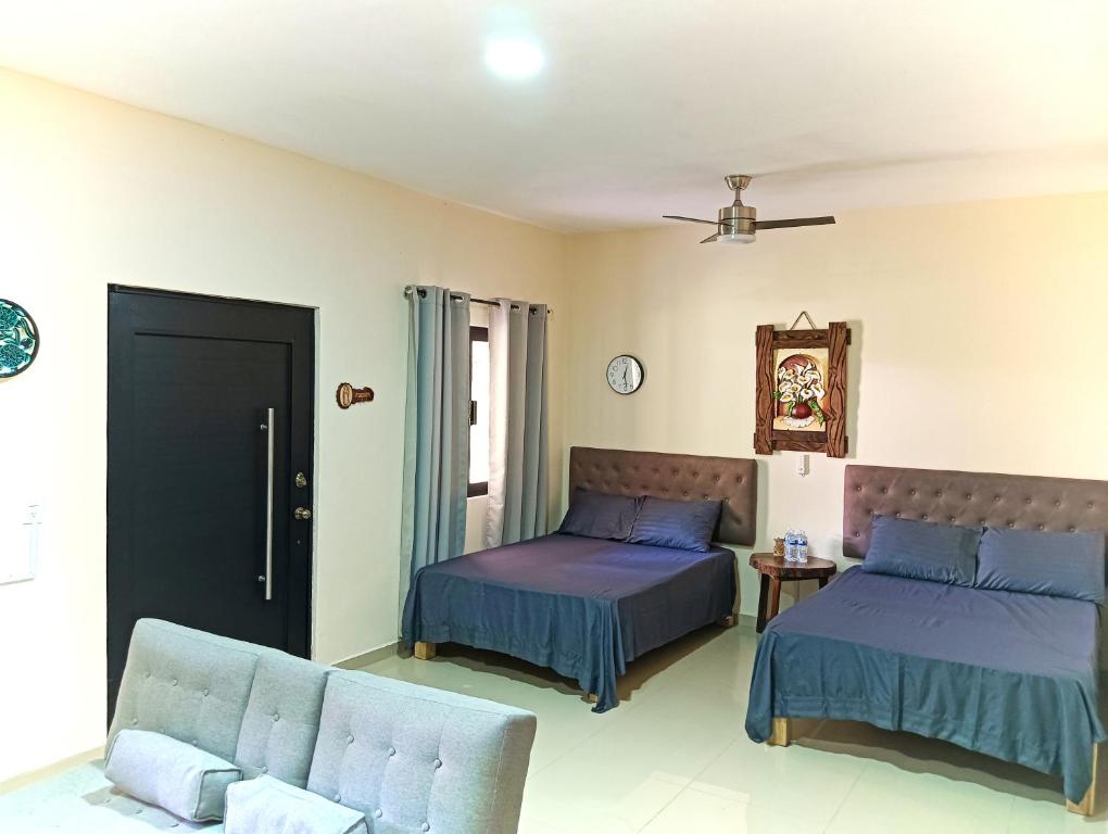 MezcalesにあるRancho Scarlettのベッド2台とソファのある寝室