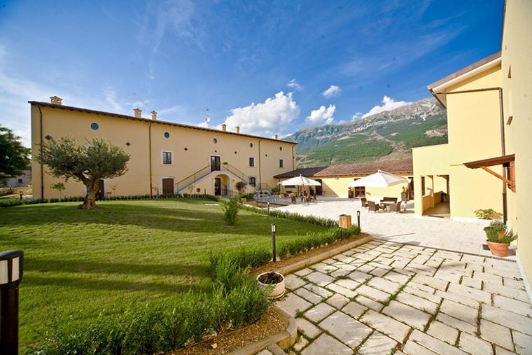 ein großes Gebäude mit einem Rasenplatz und einer Terrasse in der Unterkunft Villa Giovina in Pratola Peligna