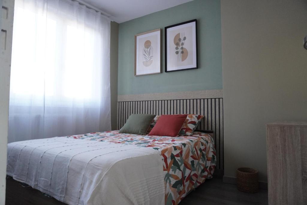 une chambre avec un lit avec des oreillers rouges et une fenêtre dans l'établissement Le Minck, à Calais