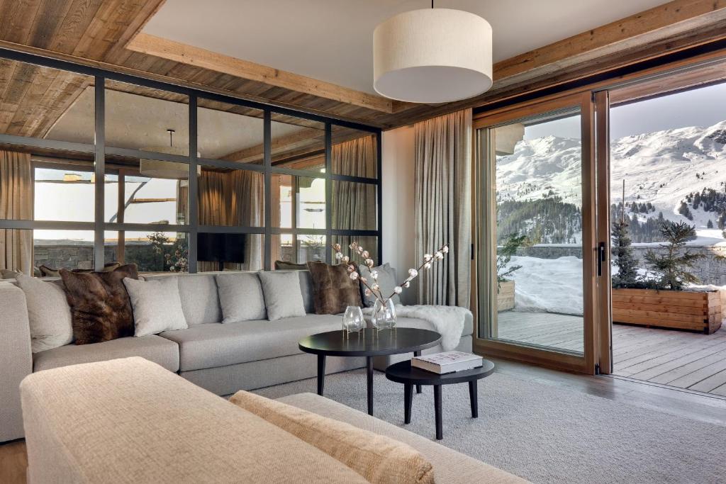 un soggiorno con un divano e un tavolo di Antarès MIRA 002 - prestige apartment ski inski out a Méribel