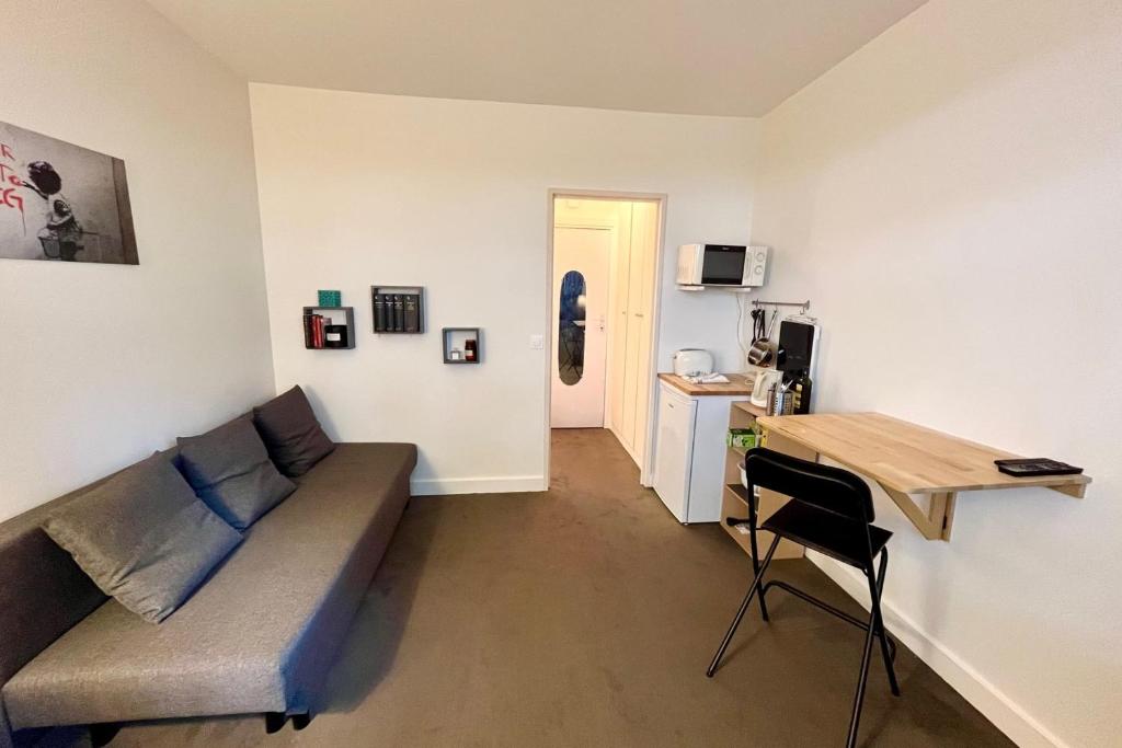 un salon avec un canapé et une table dans l'établissement Bright apartment near Parc des Princes, à Boulogne-Billancourt