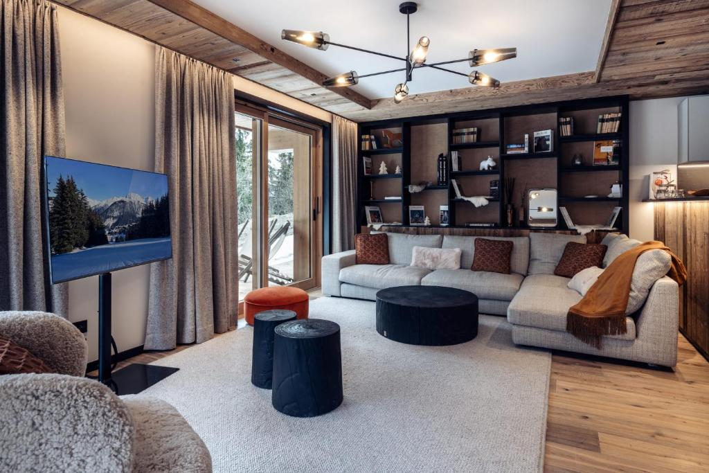 un salon avec un canapé et une télévision dans l'établissement Antarès URSA 002 - luxury apartment ski inski out, à Méribel