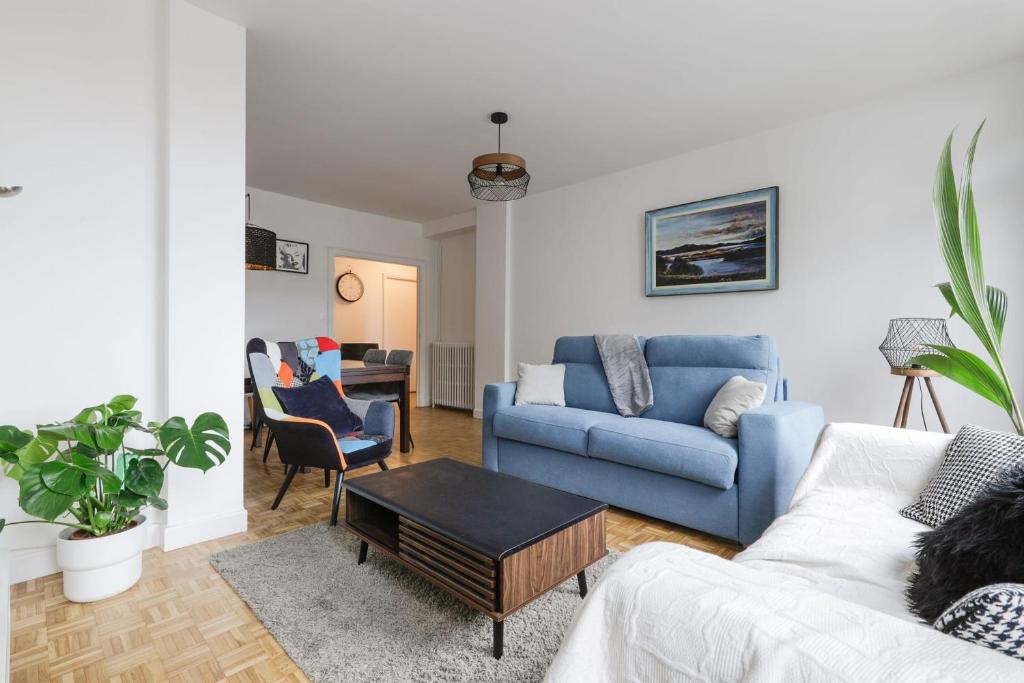 un salon avec un canapé bleu et une table dans l'établissement Bright apartment overlooking the Canal du Midi, à Toulouse
