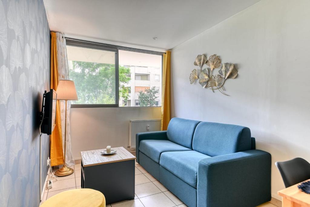 un salon avec un canapé bleu et une fenêtre dans l'établissement Apartment - 4P - Villeurbanne, à Villeurbanne
