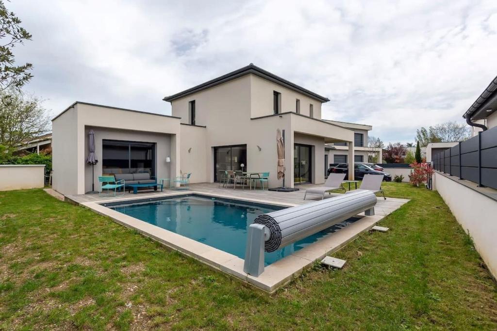 une maison avec une piscine dans la cour dans l'établissement Villa Tassin Piscine 6 Voyageurs, à Tassin-la-Demi-Lune