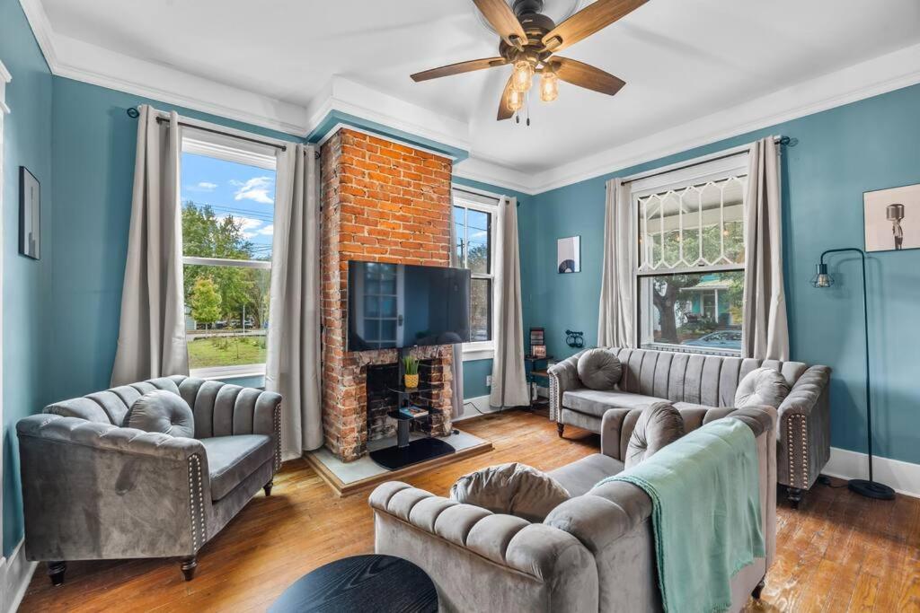 a living room with blue walls and a ceiling fan at Half Off SALE! Downtown Home with King Bed FirePit Free Parking and Huge Back Yard Filming Allowed in Wilmington