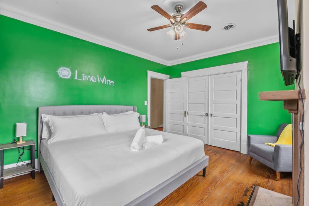 a bedroom with a white bed and a green wall at Half Off SALE! Downtown Home with King Bed FirePit Free Parking and Huge Back Yard Filming Allowed in Wilmington