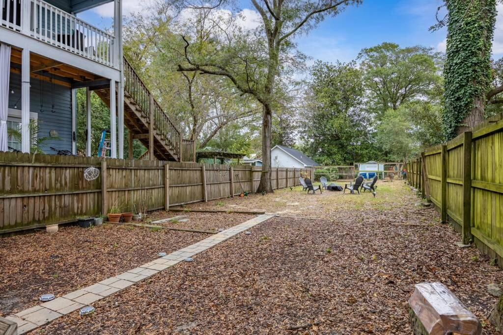 a backyard with a wooden fence and a fence at Half Off SALE! Downtown Home with King Bed FirePit Free Parking and Huge Back Yard Filming Allowed in Wilmington
