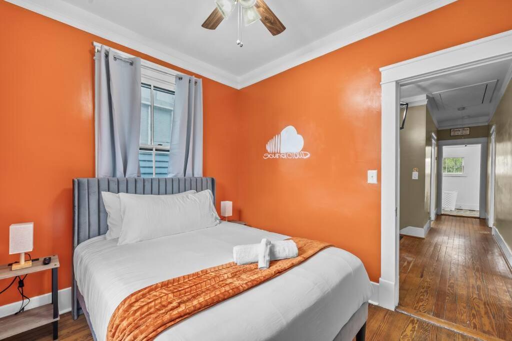 a bedroom with a bed with an orange wall at Half Off SALE! Downtown Home with King Bed FirePit Free Parking and Huge Back Yard Filming Allowed in Wilmington