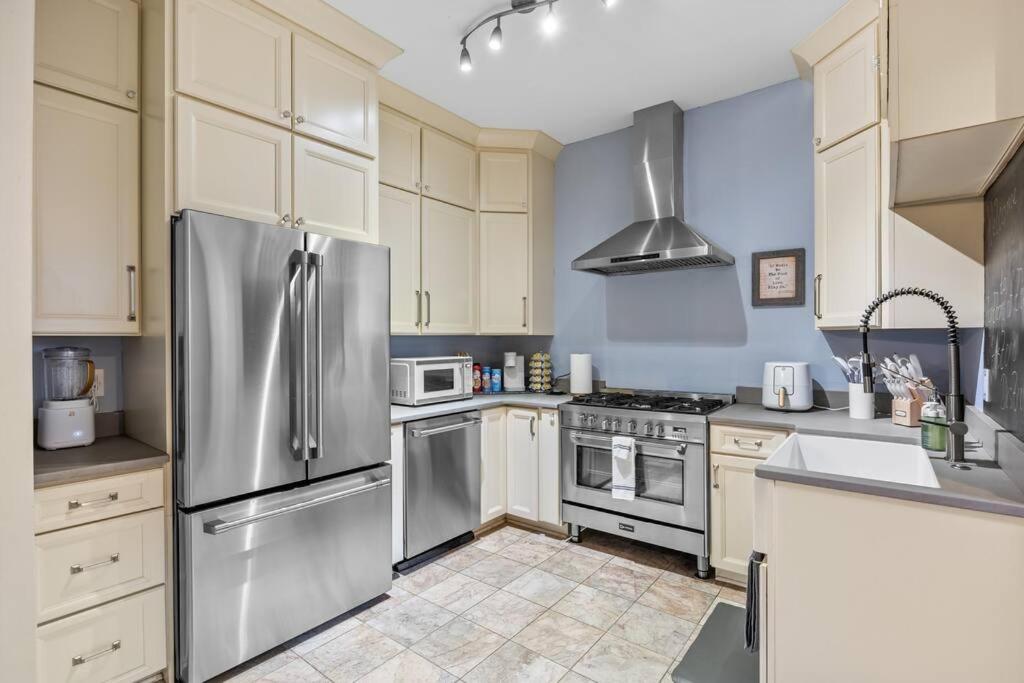 a kitchen with white cabinets and stainless steel appliances at Half Off SALE! Downtown Home with King Bed FirePit Free Parking and Huge Back Yard Filming Allowed in Wilmington