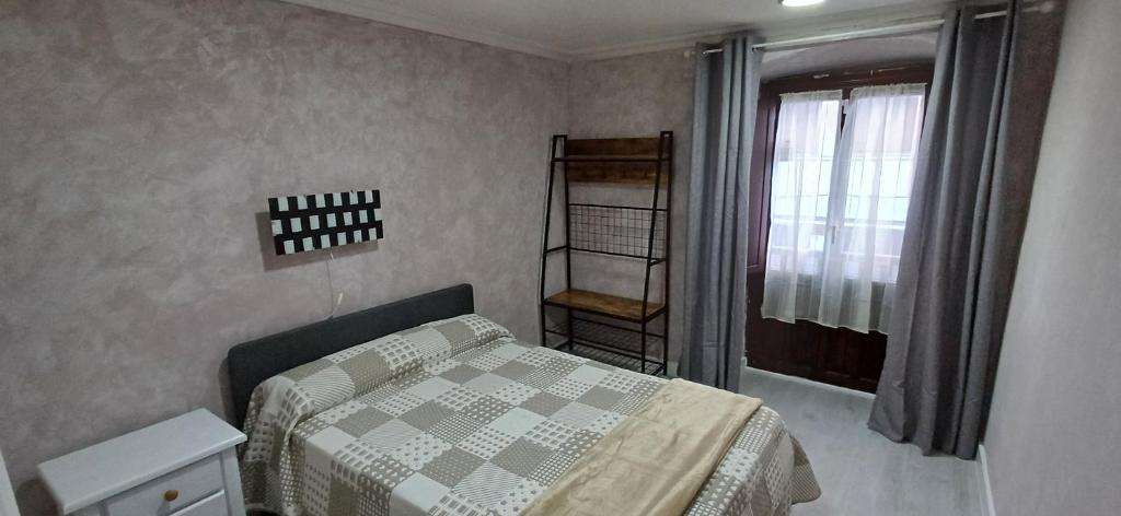 ein kleines Schlafzimmer mit einem Bett und einem Fenster in der Unterkunft Duplex Acogedor en Areatza, cerca del Parque Gorbea in Areatza