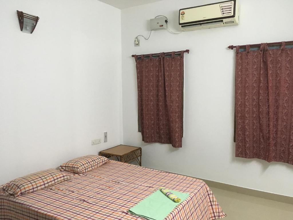 a small bedroom with a bed and a tv at Peaceful Pondy near Aurobindo ashram & ROCK BEACH in Pondicherry