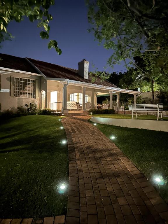 a house with a brick walkway in front of a yard at The Manor at Chaplin Manor in Johannesburg