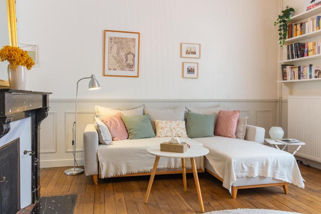 una sala de estar con un sofá y una mesa en Le Jardin Des Délices charming house in Troyes, en Troyes