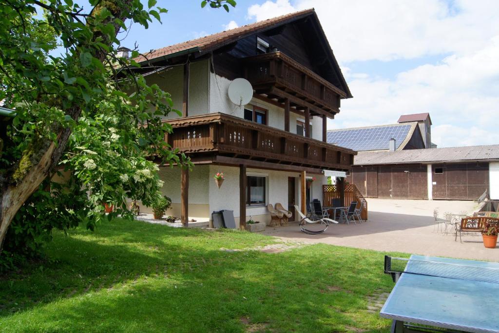 a large house with a patio and a yard at Bio-Erlebnisbauernhof Doll in Nittenau