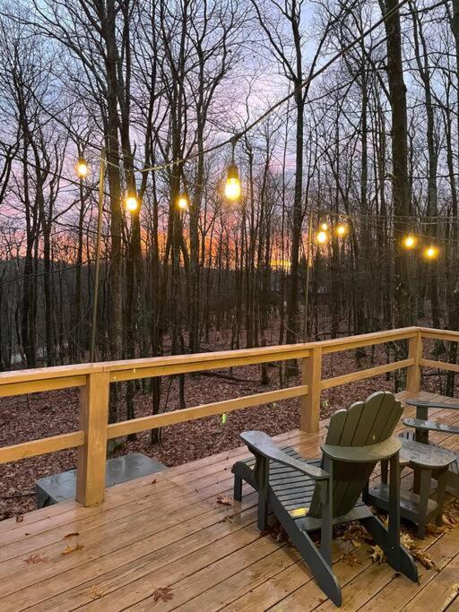 a wooden deck with a chair and a bench on it at Cozy Log Cabin Near Ski Area and Lake including Hot Tub in Swanton