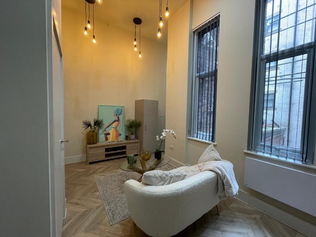 a living room with a white couch and windows at Stylish Apartment in Leeds City Centre in Central Station