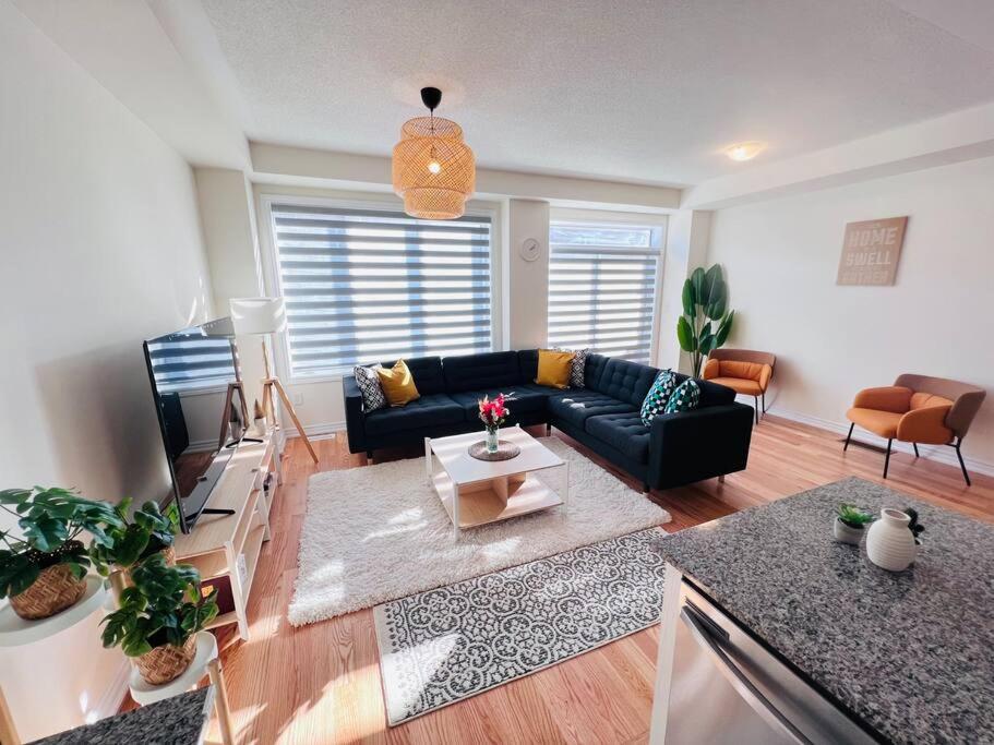 a living room with a couch and a table at Brand New Luxurious 4B Townhouse in Oshawa