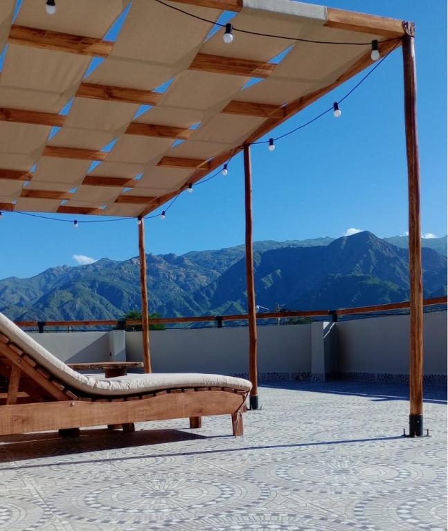 a porch with a bench and a view of mountains at Posada del Musiquero in Cafayate