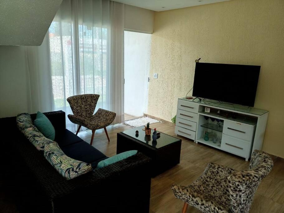ein Wohnzimmer mit Couch und Flachbildfernseher in der Unterkunft Linda Casa em Praia de Gravatá in São José da Coroa Grande