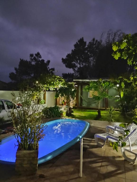 a swimming pool in a yard at night at Casa de praia natureza in Torres