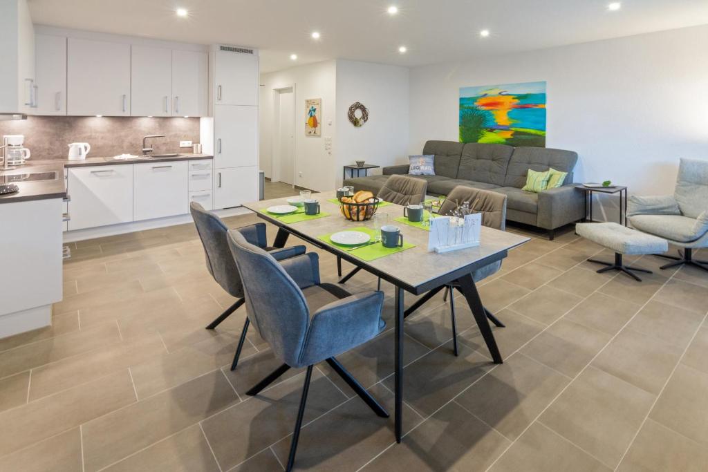 a kitchen and a living room with a table and chairs at Oase am Siel 4 in Dornumersiel