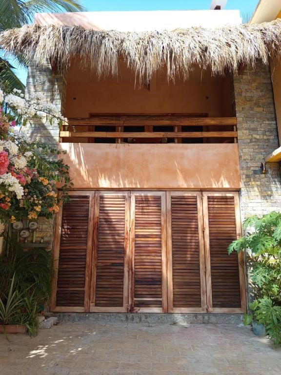 a house with wooden doors and a thatched roof at Casa XhunaXhia in Zipolite