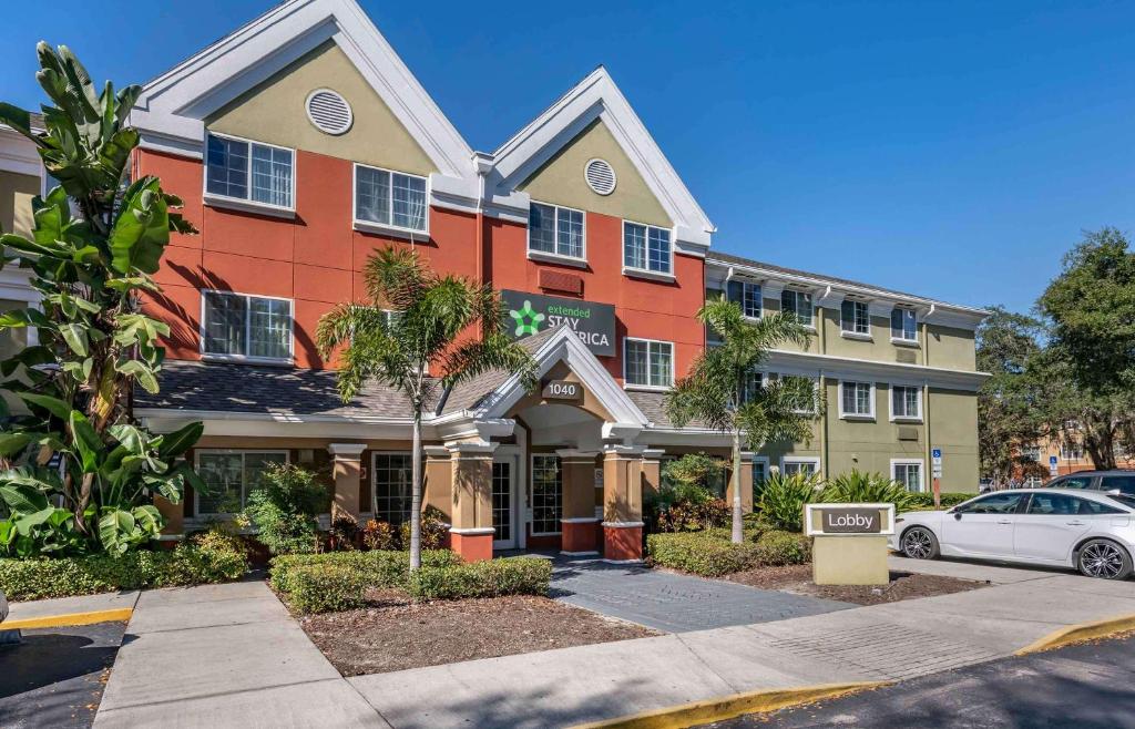 a building with a car parked in front of it at Extended Stay America Select Suites - Orlando - Lake Mary - 1040 Greenwood Blvd in Lake Mary