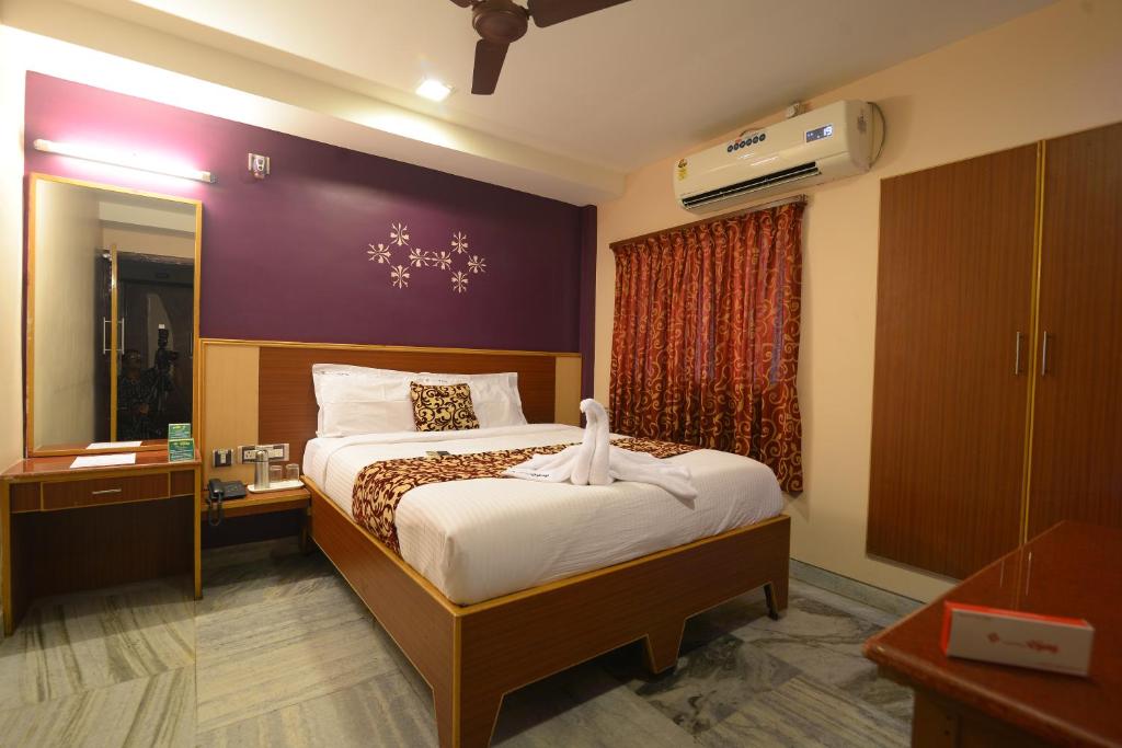 a bedroom with a large bed and a window at Hotel Vijay in Madurai