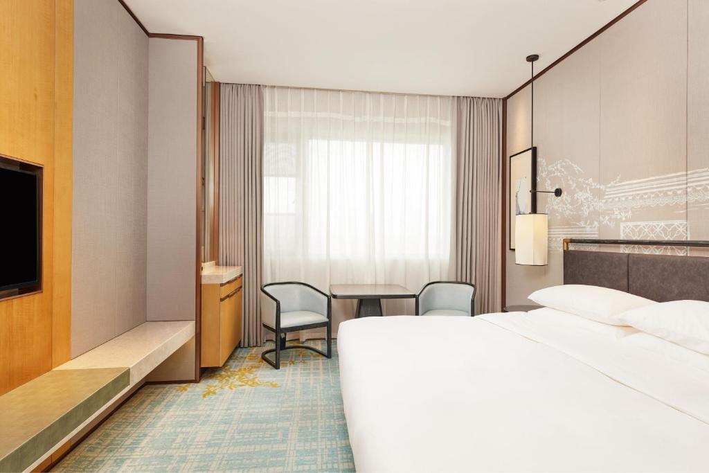 una habitación de hotel con una cama y un escritorio en Courtyard by Marriott Yangzhou, en Yangzhou