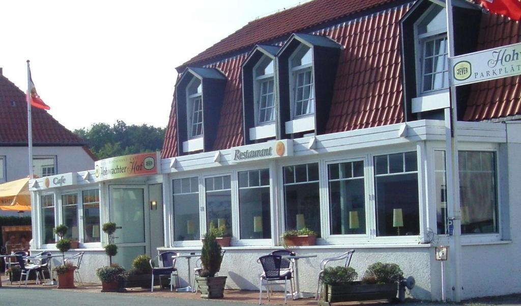 un edificio con ventanas y sillas delante de él en Hohwachter Hof, en Hohwacht