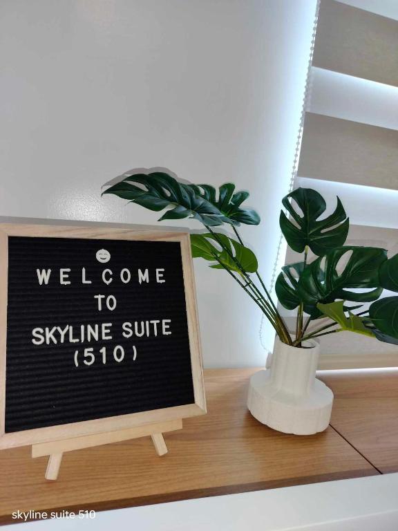 a sign on a shelf with a potted plant on it at Skyline Suite 510 at Mesavirre Garden Residences in Bacolod