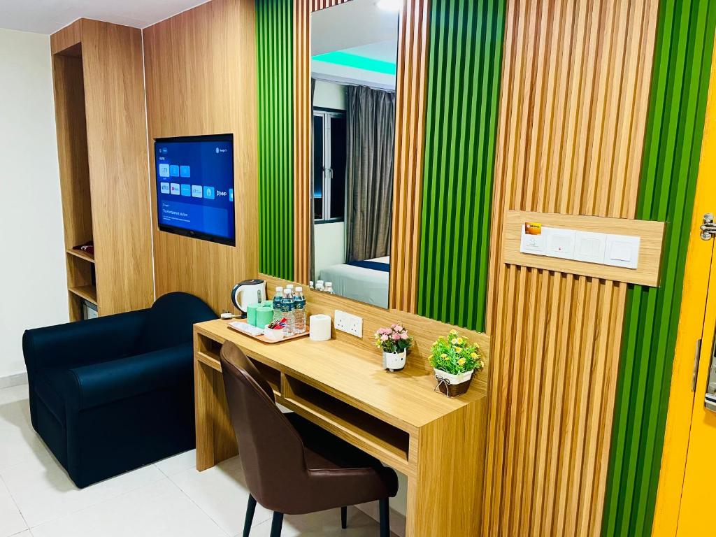A compact in-room workstation beside a lounge chair, television, and refreshment tray.