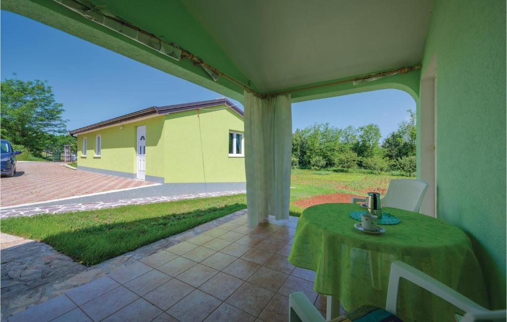 zadaszone patio ze stołem i żółtym budynkiem w obiekcie Studio Apartment In Sv,lovrec w mieście Jakići