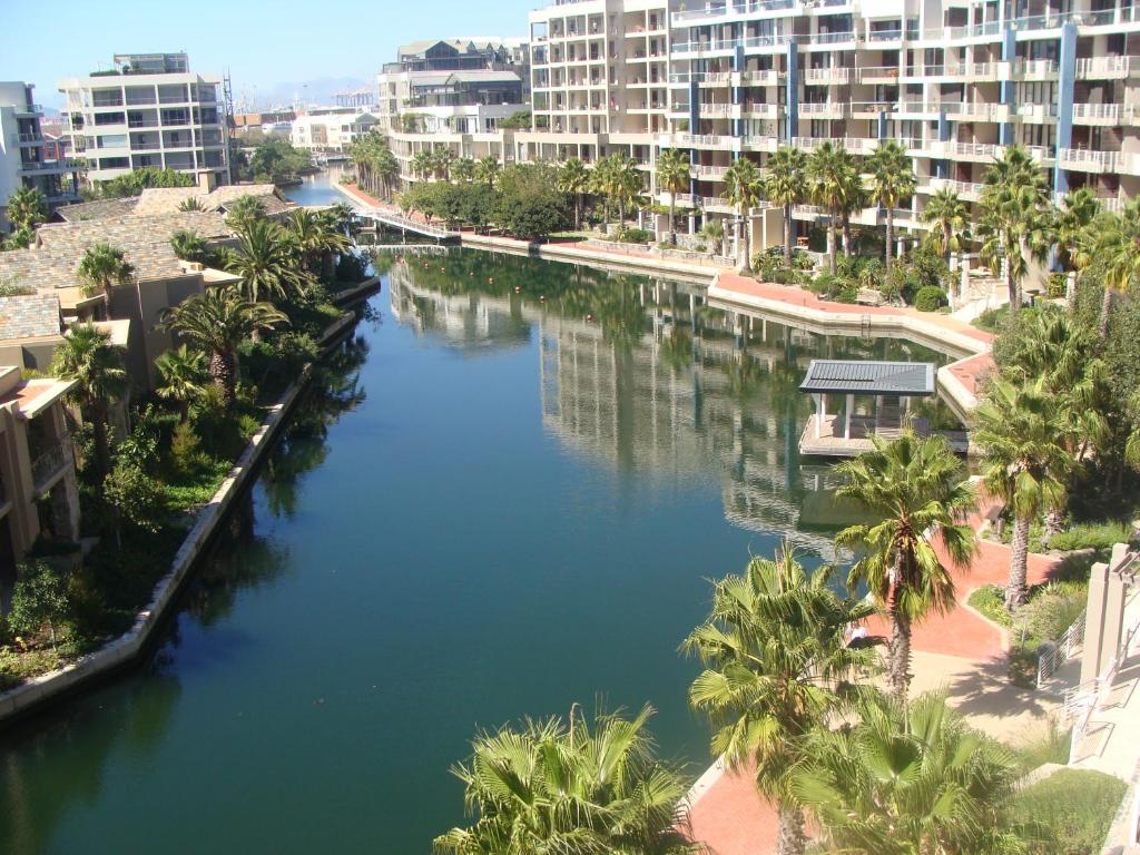 a river in a city with palm trees and buildings at 202 Kylemore A Waterfront Marina in Cape Town