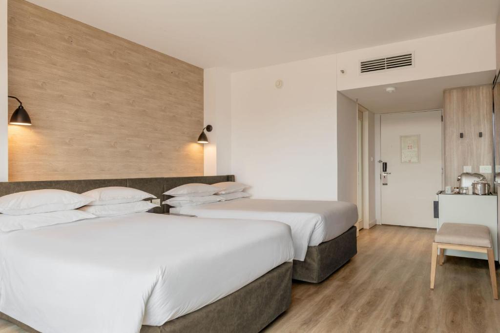 a hotel room with two beds and a kitchen at Sheraton Buenos Aires Hotel & Convention Center in Buenos Aires