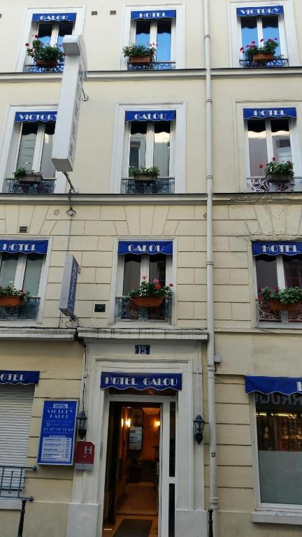 a building with windows and potted plants on it at Victory Hotel Galou in Paris