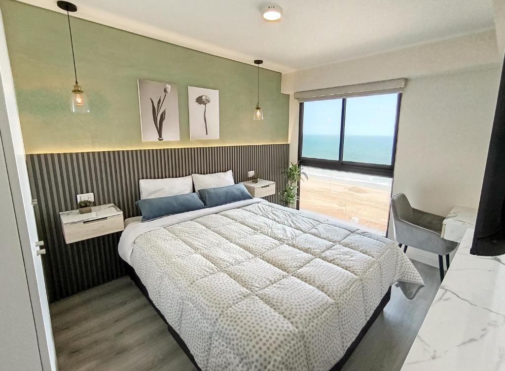 a bedroom with a large bed and a large window at Elegante Departamento Con Vista al Mar Full Comodidad in Lima