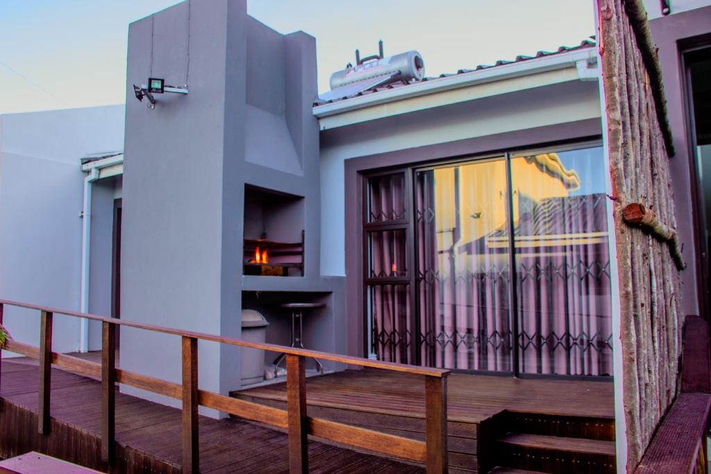a balcony of a house with a wooden railing at Gaiaqua Guesthouse in Gqeberha