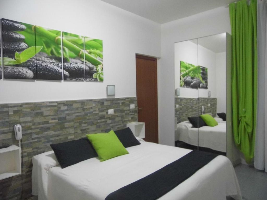 a bedroom with two beds with green accents at Hotel Birillo in La Spezia