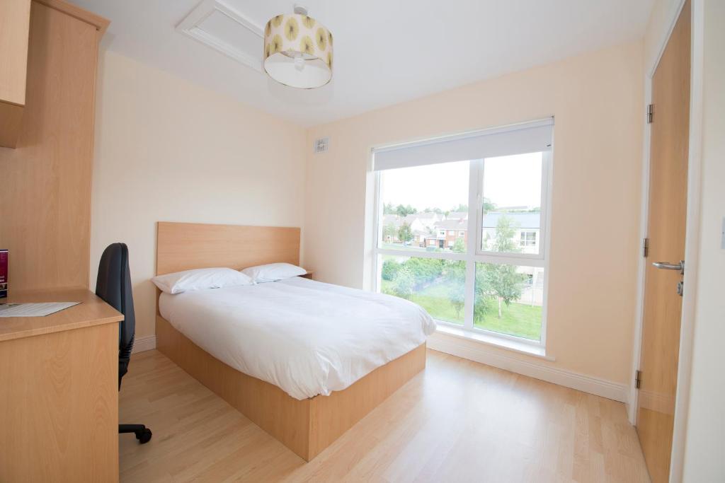 a bedroom with a bed and a large window at Troy Self Catering Village Limerick Ireland in Limerick