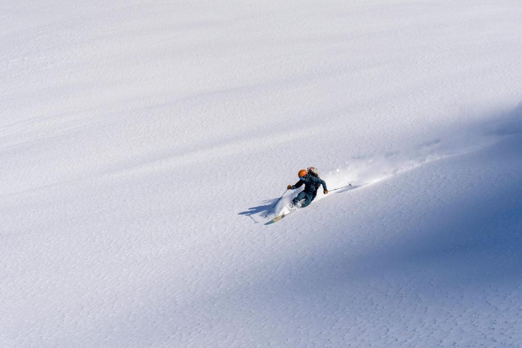 a person skiing down a snow covered slope at SCHLOSS Zermatt - CBD & Adaptogenic Spa and Sport Hotel in Zermatt
