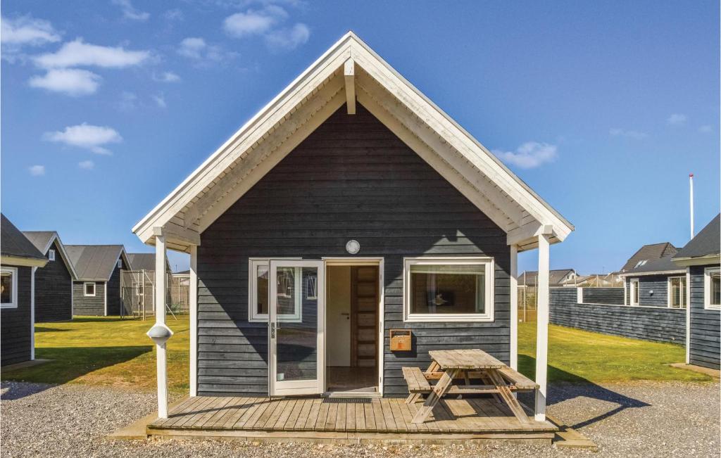 a small black house with a picnic table in front of it at Hytte 11 in Thyborøn