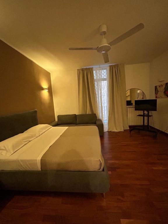 een slaapkamer met een bed en een plafondventilator bij AnNì apartment Chiaia in Napels