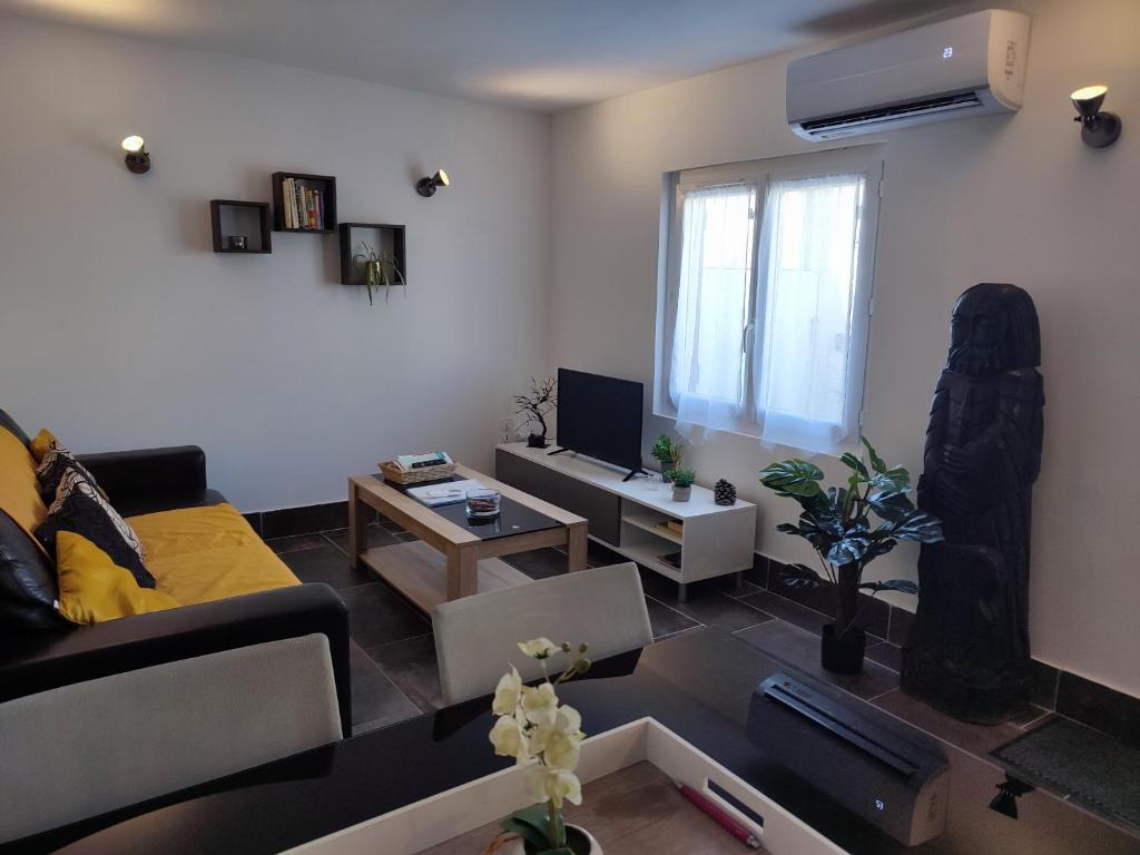 un salon avec un canapé et une table dans l'établissement Mas Boucard II : plage cour et parking privés, à Frontignan