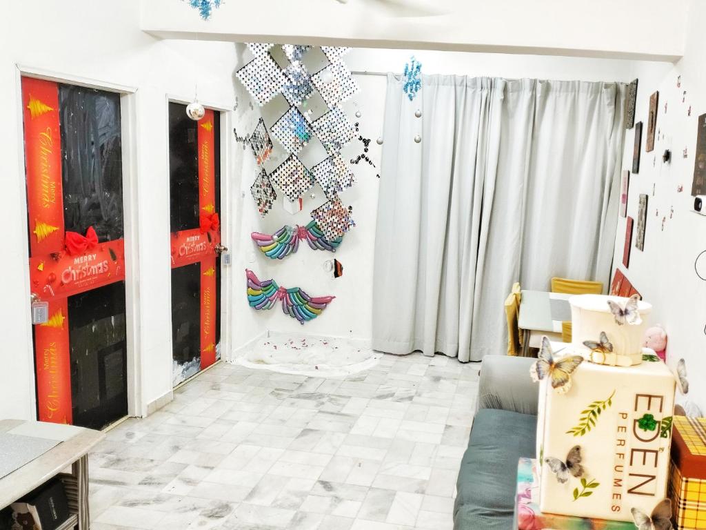 una sala de estar con mariposas en la pared en Simple life homestay, en Melaka