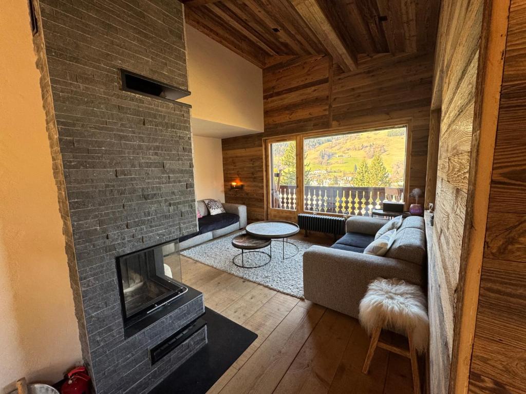 un salon avec un canapé et une cheminée dans l'établissement Duplex aux pieds des pistes à Rochebrune, à Megève
